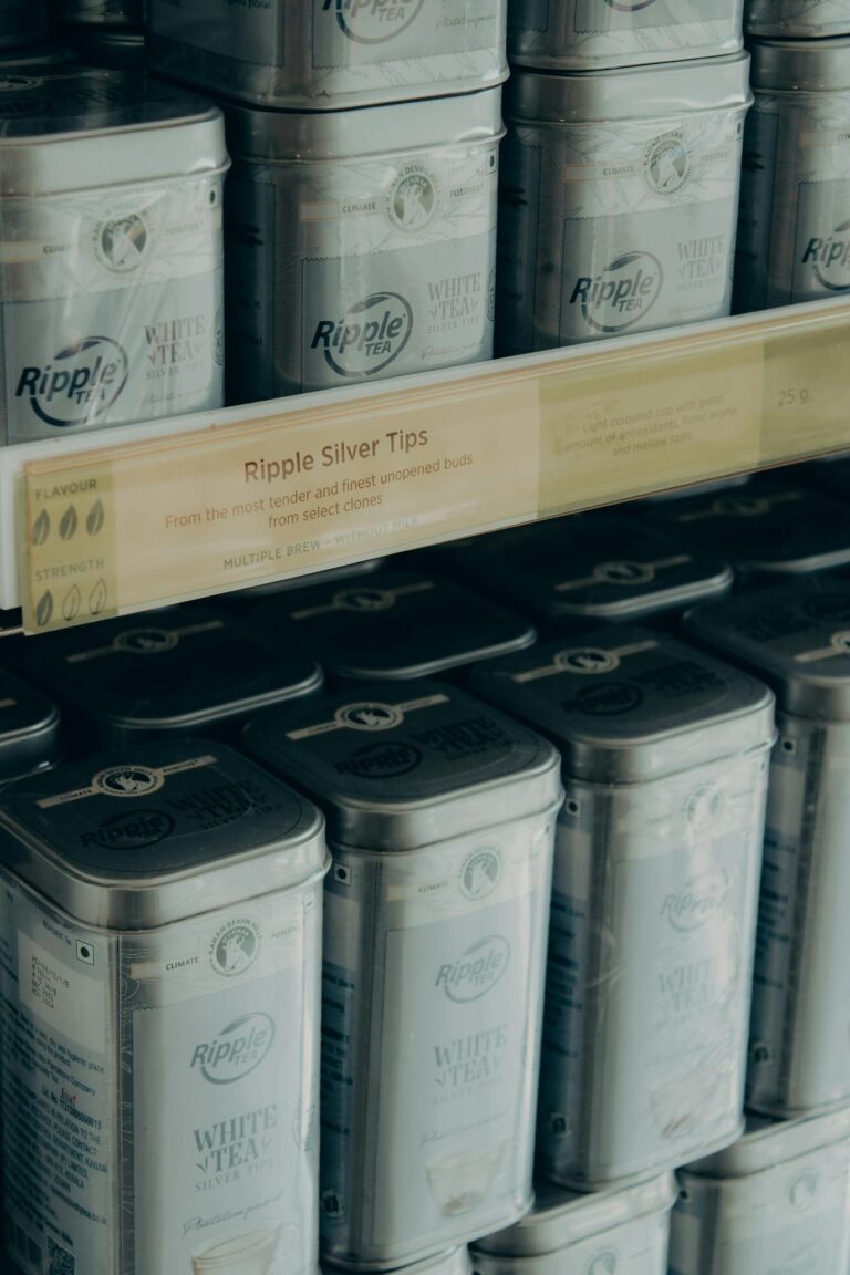 Close-up of Ripple Silver Tips white tea tins on an organized shelf in Munnar, India.